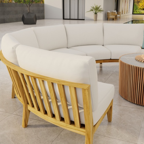 70881 Kafelonia 7 pc Lounge Set in angle aerial view of 6 Sofa Sectional Benches and Agora Fire Table in center of set on tiled patio in front of a pool with house in background 
