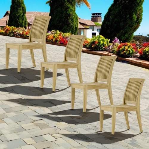 70885 Laguna Side Chair Set of 4 Side Chairs on paver terrace surrounded by plants and trees with ocean views and house and blue sky background 