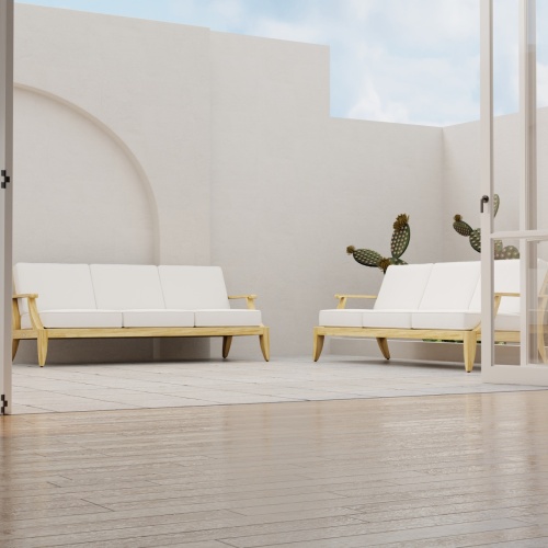 70916 Laguna Teak Sofa Set of 2 Laguna Teak Sofas in front view on patio with privacy wall and cactus in background