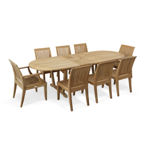 70926 Laguna Montserrat 9 piece Dining Set of Montserrat Oval Teak Table and 2 Laguna Dining Armchairs and 6 Laguna Side Chairs in angled end view on patio with ocean in background