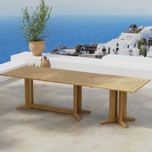70936 Pyramid Teak Table Set of Pyramid Teak Rectangular Table and Square Table in angled side view on outdoor terrace with houses and ocean in background