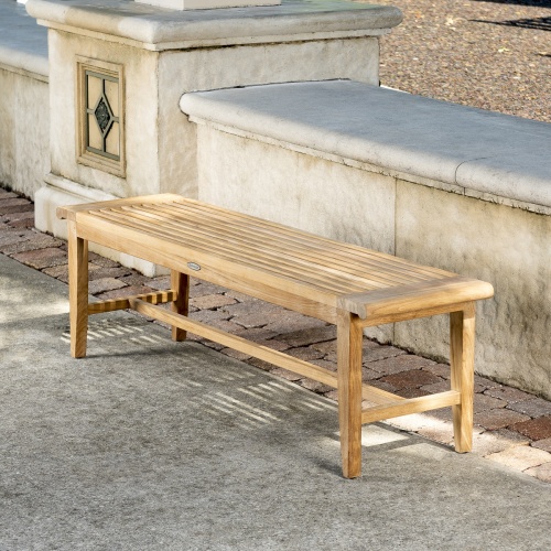 13916 Laguna Teak 5 foot Backless Bench angled view on concrete stone patio with concrete low wall in background