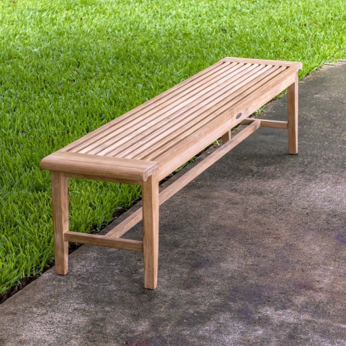 13917 Laguna 6 foot teak Backless Bench on concrete walkway with trees and pavilion in background