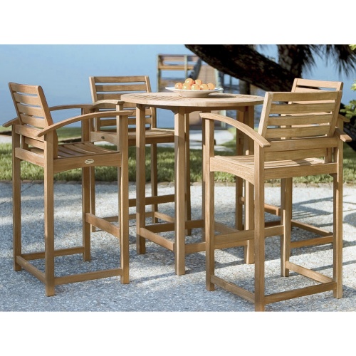 15334 Somerset Teak Round 36 inch diameter Table and 4 chairs bowl of oranges on table set on stone patio with palm trees and ocean in background