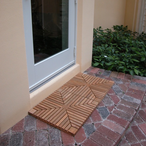 18408 diamond teak tiles showing two tiles in front of doorway on brick walkway