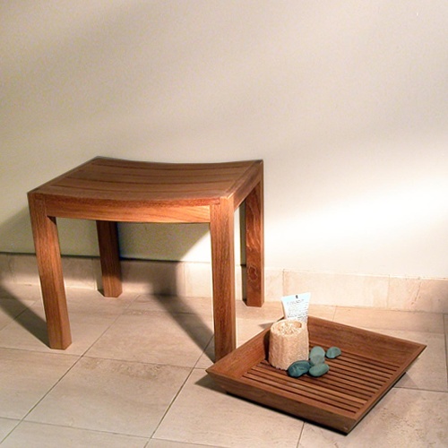 18625 Pacifica Stool up against wall on tiled floor with loofah and black stones lotion on tray on right side on tile floor
