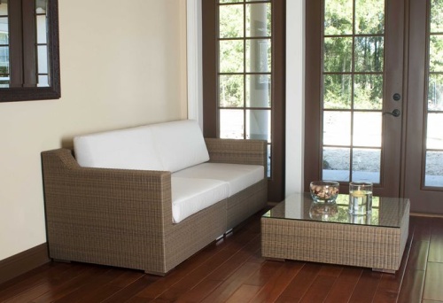 31004 malaga synthetic wicker deep seating sectional side view on wood floors wall mirror behind sofa bowl and floating candle on table with french doors overlooking patio 