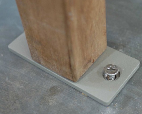 40010 Bench Anchor Bracket showing bracket on bottom leg of bench affixed to concrete