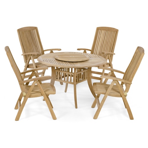 70045 Hyatt Recliner 5 piece round teak Dining Set on a grass lawn with white bowl of green apples on table and trees and shrubs in background