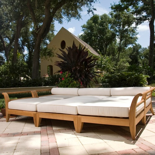 70100 Aman Dais 6 pc Daybed Set  with cushions front view on wood deck and stone patio next to potted tree and blue sky and ocean background