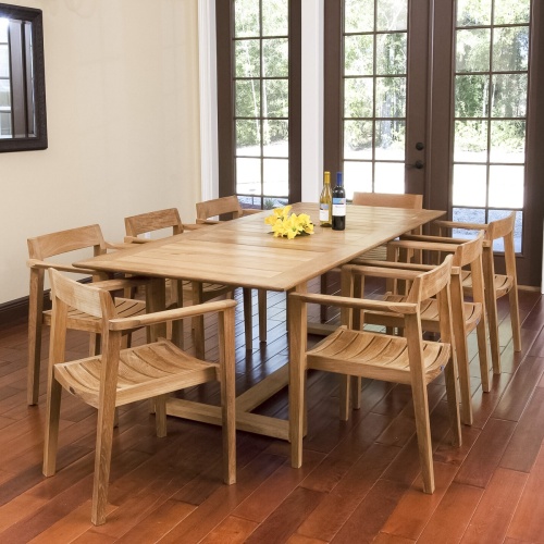 70220 Horizon 9 pc Teak Dining Set of Horizon Rectangular Extension Table and 8 Dining Armchairs with optional seat cushions side angled on wood deck with ocean in the background