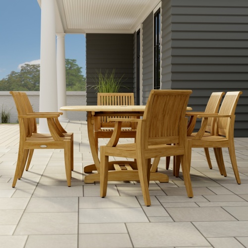 70306 Martinique 7 pc Teak Dining Set of Martinique Teak Oval Extending Dining Table and 6 Laguna DIning Chairs side view on stone patio with a house window and door in the background