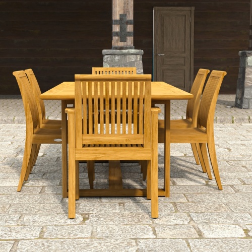 70377 Horizon Laguna 7 pc Teak Dining Set of Horizon Dining Table and 2 Laguna DIning Arm Chairs and 4 Side Chairs on paver patio with landscaping plants and ocean and cliffs in the background