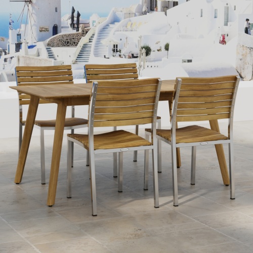 70552 Vogue Surf 5 pc Dining Set of Surf Table and 4 Vogue Side Chairs on an outdoor terrace in angled side view with homes and ocean in background
