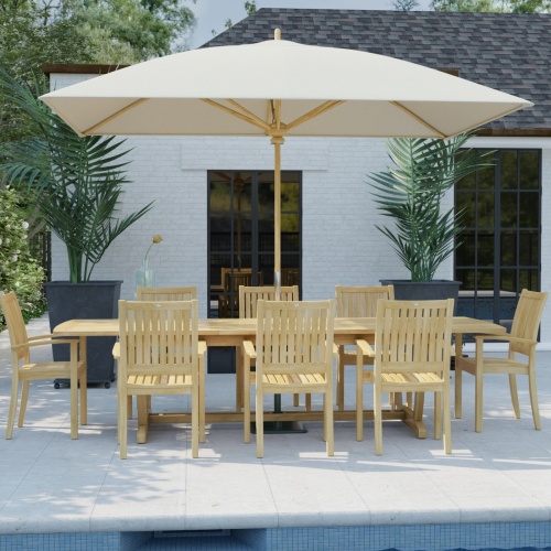 70759 Sussex Veranda 9 pc Teak Patio Dining Set with optional umbrella in angled side view on pool deck with house and windows and 2 potted plants in background 