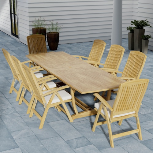 70796 Teak 9 piece Reclining Dining Set in angled aerial view on slate tiled patio in front of a fireplace and window of house and grass and trees in the background  