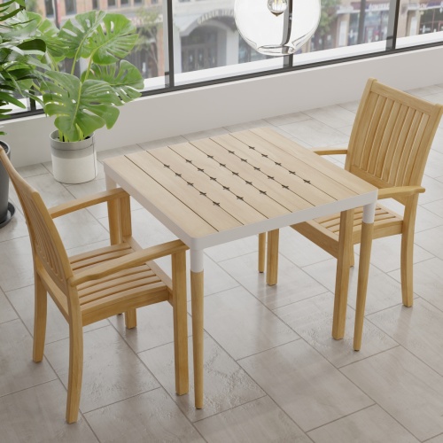  70907 Bloom Sussex 3 pc Dining Set of a Bloom Teak & Powder Coated Aluminum Square Table and 2 Sussex Armchairs aerial view on tiled floor with 2 plants and windows in background
