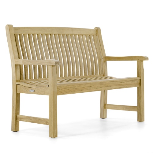13218 Veranda Teak 4 foot Bench beside trash receptacle on grass field with garden in front and trees in background