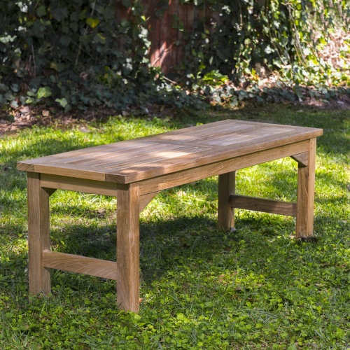 13940 Veranda 4 foot Teak Backless Bench side view on grass area with trees & shrubs in background