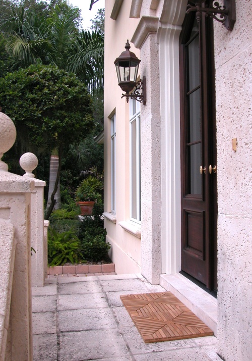 18408 diamond teak tiles showing two tiles in front of doorway angled view on brick walkway