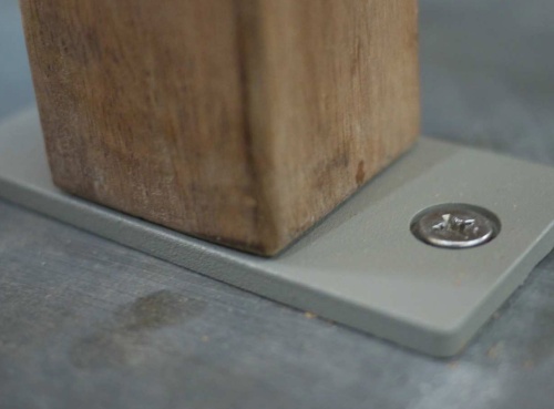 40010 Westminster Bench Anchor Bracket attached to Outdoor Teakwood Bench bottom leg closeup showing bracket attached to concrete floor 