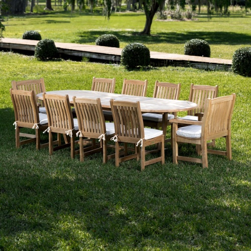 70008 Montserrat Veranda eleven piece teak oval dining set side angle view on a grass field 