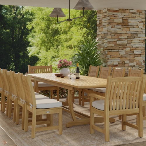 70017 Grand Veranda 13 piece dining set with optional seat cushions and optional market umbrella bowl of apples a plate of bread wood bowls plates on grass with dock and lake background