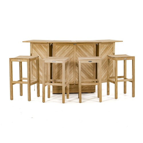  70084 somerset teak five piece bar set showing three wine glasses and wine bottle on top with stone patio a grass area paver walkway and lush tropical plants in background