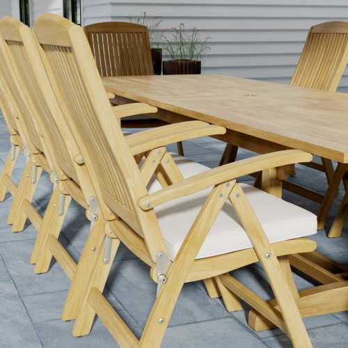 70205 Reclining Teak 11 pc Dining Set showing closeup angled side view of Barbuda Folding Armchairs with optional seat cushions and Grand Veranda Dining Table on outdoor patio