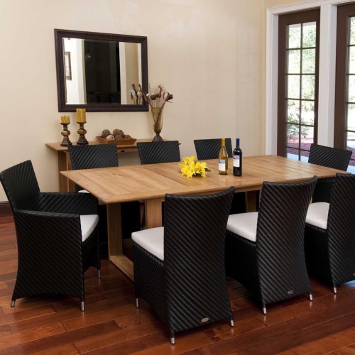  70248 Valencia 7 piece Dining Set with 2 wine bottles and yellow flowers on table center on wood floors indoors wall mirror side table with 2 pillar candles vase of dried flowers on back wall