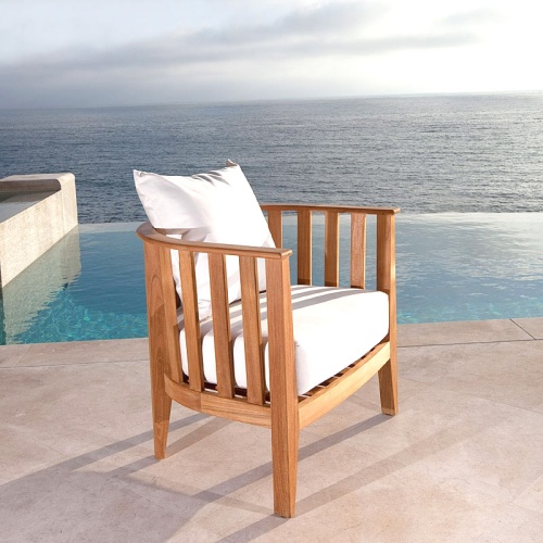 70271 Kafelonia 7 piece Lounge Set on outdoor patio in front of a potted plant and landscaping plants with ocean in background