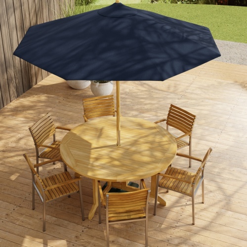70349 Barbuda Vogue Teak 7 pc Dining Set with optional umbrella in angled aerial view on paver patio with wood privacy wall with landscaping plants and trees in background