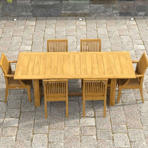 70377 Horizon Laguna 7 pc Teak Dining Set showing end view on paver patio with stone and wood pillars and wall and door in the background 