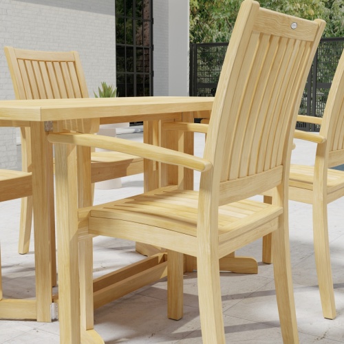 70607 Sussex Nevis 5 pc Dining Set of Nevis Rectangular Folding Table and 4 Sussex Dining Armchairs in partial angled side view on patio with windows in background 