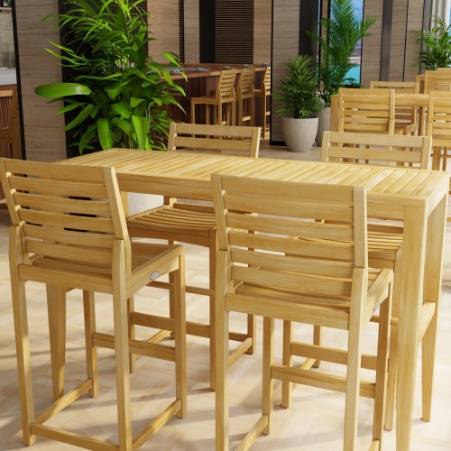 70649 Laguna Somerset Side Barstool Set in a hospitality setting showing 4 sets in side view surrounded by potted plants next to a wall of windows overlooking the ocean