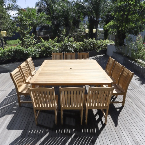 70879 Veranda 13 piece teak Square Dining Set with optional seat cushions angled view on deck with trees shrubs and buildings in background