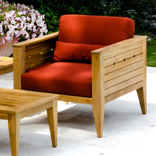 12160dp Craftsman teak cushioned armchair set front angled on concrete patio potted blooming plant and landscaped background