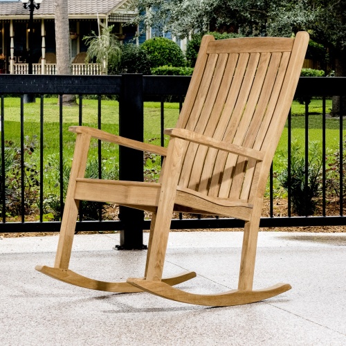 12223 veranda teak rocking chair on porch side angle view with railing and landscaped lawn in background
