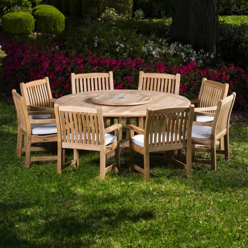 70173 9 piece Buckingham Armchair Teak Set on grass field with flowers and shrubs in background 