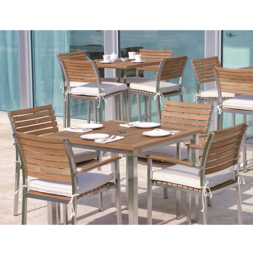 25190 Vogue Bistro teak and stainless steel 36 inch Square Table with 5 piece Vogue Dining Set with vogue bar set and glass patio doors in background