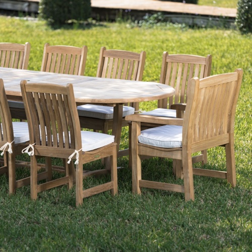 70008 Montserrat Veranda eleven piece oval dining set side view on a grass field with background of trees a boardwalk and lake 