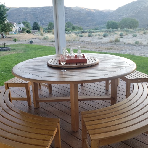  70090 Buckingham Picnic Dining Set with grapes in bowl stack of plates 4 glasses and napkins on table side view on grass field with trees in background