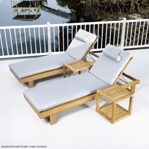 70308 Horizon teak double chaise set with cushions left side angled on concrete deck with metal railing trees boathouse and dock in background