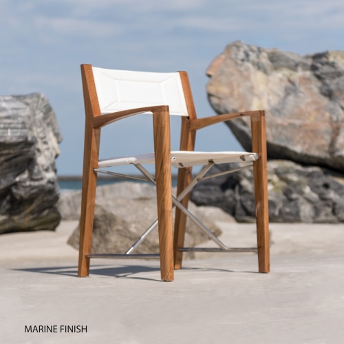 70745 Odyssey director chair angled right side view on sandy beach in front of large boulders with ocean and blue sky view in background 
