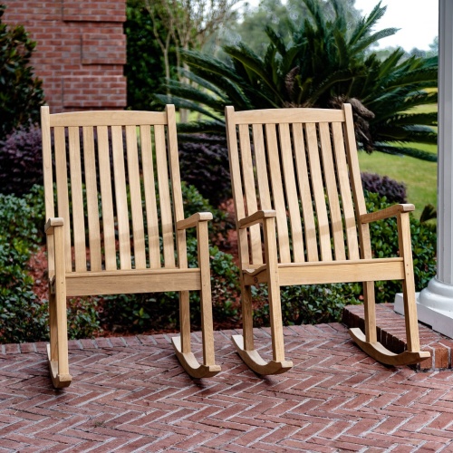 12223 Veranda Teak Rocking Chair on porch in side view with railing and landscaped lawn in background