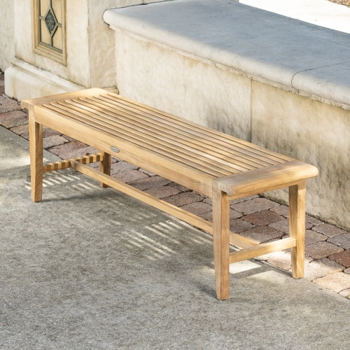 13916 Laguna Teak 5 foot Backless Bench angled view on concrete stone patio with concrete low wall in background