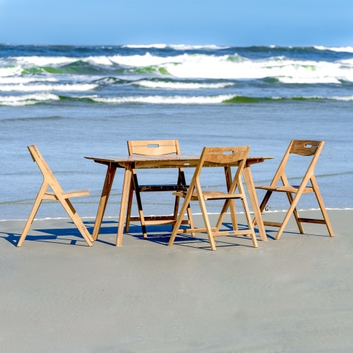 70528 Surf 5 pc Teak Dining Set on sandy beach overlooking ocean and blue sky background