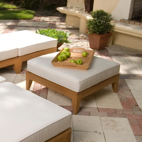 16767dp aman dais sectional set top view two ottoman fill base with cushions a teak serving tray with bowl of grapes on a paver patio with potted plants