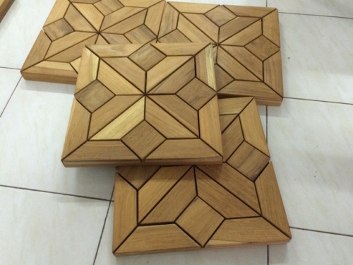 18171 Fez Teak Tiles showing one carton of 4 tiles measuring 4 square feet in arabesque style design with one tile on top of three on a tiled floor