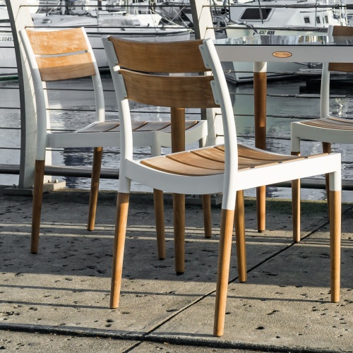 70556 Bloom teak and powder coated aluminum side chair angled rear view facing boat marina on white background